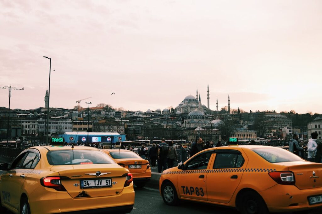 pexels-photo-31232045 Yellow taxis navigate busy Istanbul streets with iconic mosques in the background.